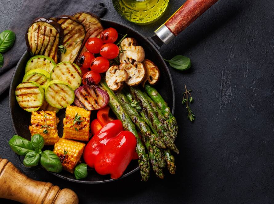 Assorted grilled vegetables on a frying pan, showcasing a colorful and healthy meal